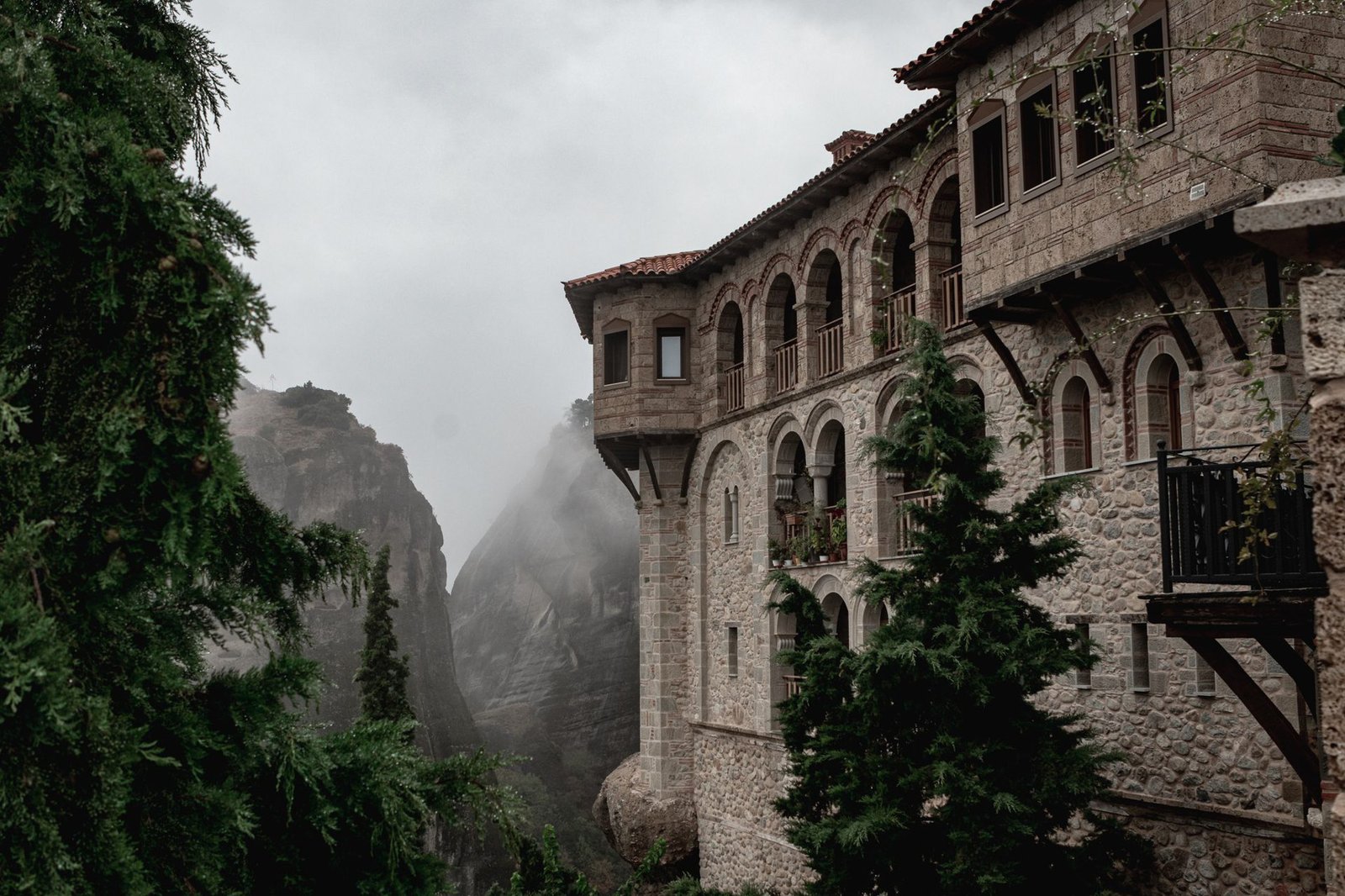 Stunning view of a historic Meteora monastery surrounded by fog and nature - Greece