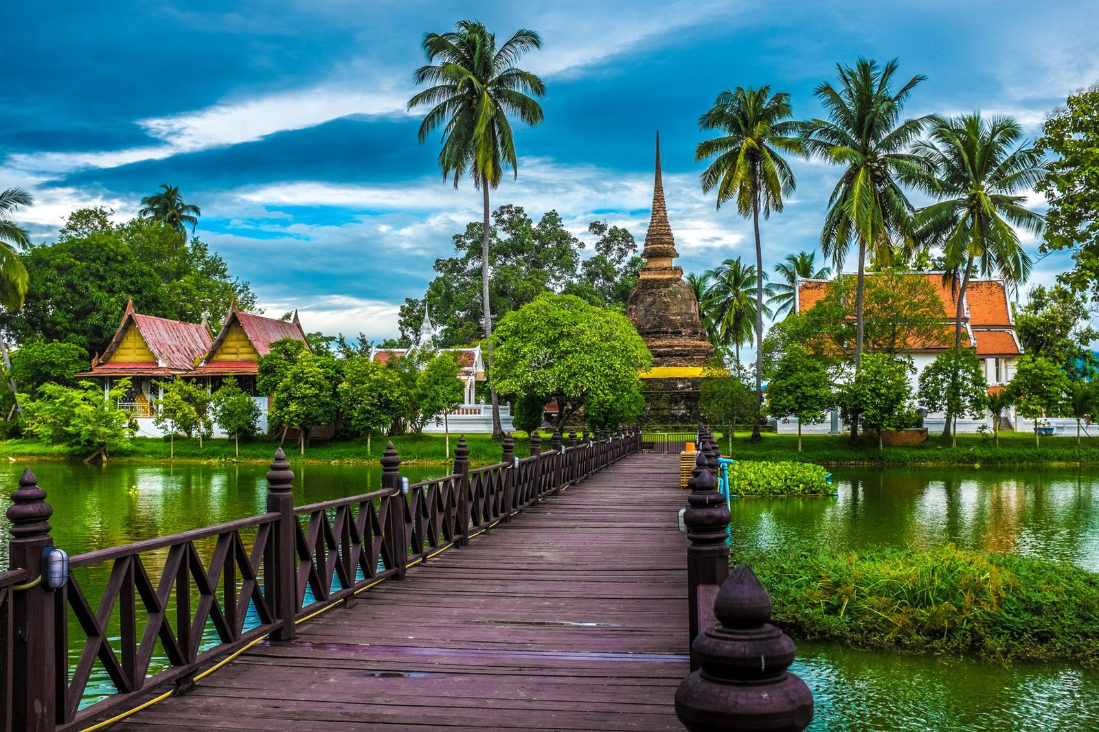 The tranquil beauty of Sukhothai's temple surrounded by lush greenery and serene waters - Mueang Kao, Thailand